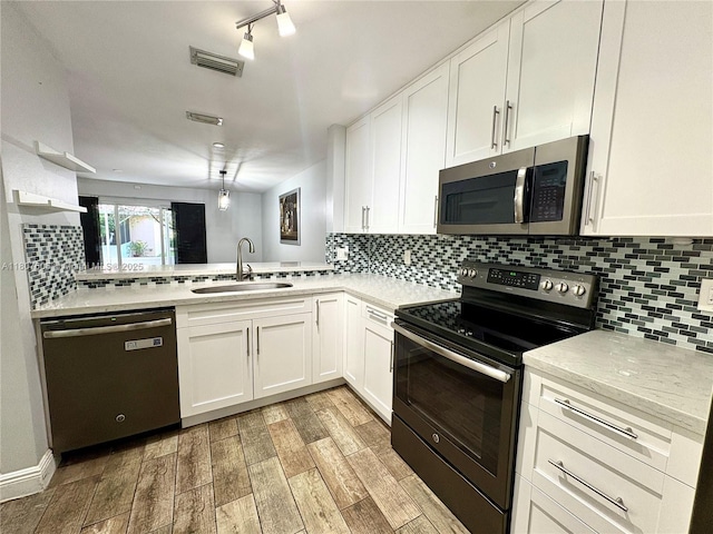 20866 NW 3rd Ln, Pembroke Pines, FL 33029 - kitchen with appliances with stainless steel finishes, light wood-style flooring, white cabinetry, and tasteful backsplash