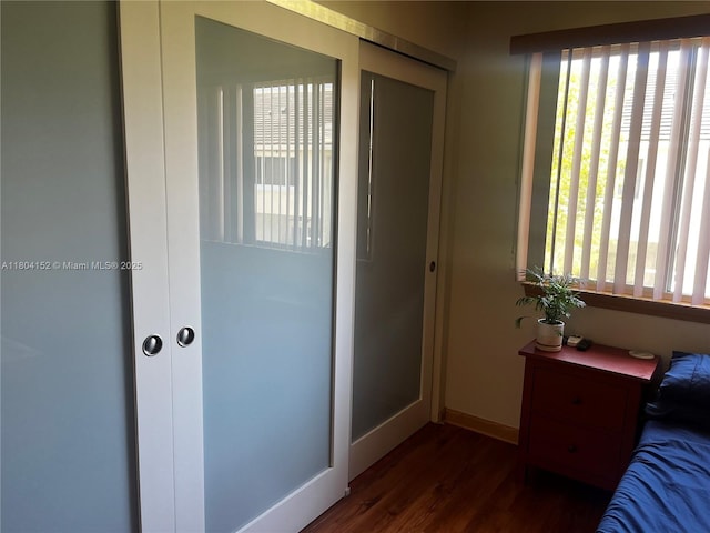 9955 NW 56th Pl, Coral Springs, FL 33076 - bedroom featuring multiple windows, dark wood-type flooring, and baseboards