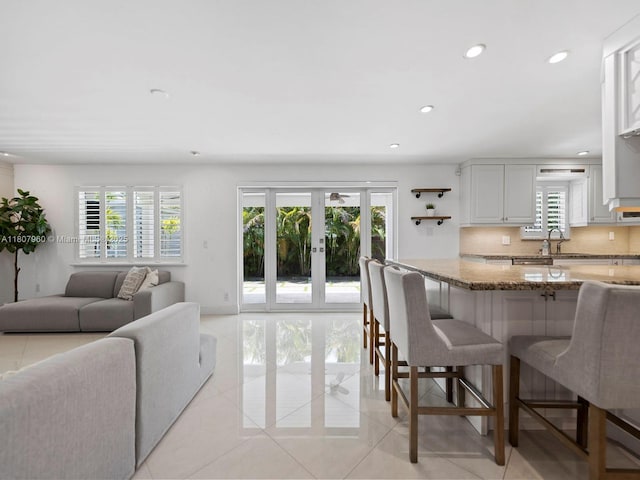 5930 SW 13th Ter, West Miami, FL 33144 - kitchen featuring a kitchen breakfast bar, light stone countertops, recessed lighting, light tile patterned floors, and tasteful backsplash
