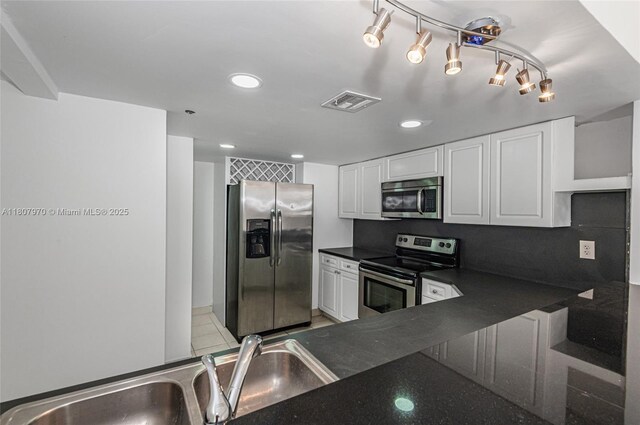 555 NE 15th St Unit 603, Miami, FL 33132 - kitchen featuring appliances with stainless steel finishes, dark countertops, white cabinets, a sink, and recessed lighting