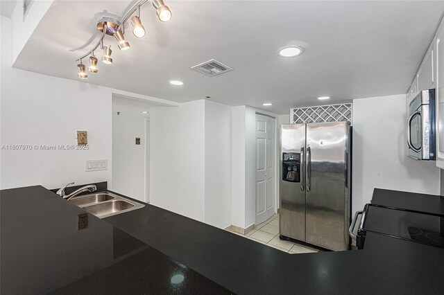 555 NE 15th St Unit 603, Miami, FL 33132 - kitchen featuring stainless steel appliances, a sink, recessed lighting, light tile patterned floors, and dark countertops