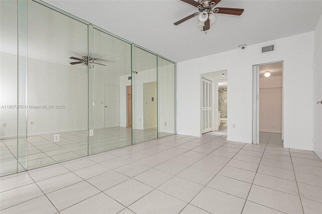 555 NE 15th St Unit 603, Miami, FL 33132 - unfurnished bedroom featuring tile patterned flooring, a ceiling fan, ensuite bath, and a spacious closet
