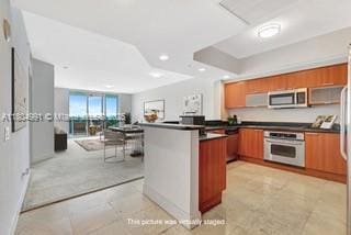 14951 Royal Oaks Ln Unit 1406, North Miami, FL 33181 - kitchen with stainless steel appliances, dark countertops, a peninsula, open floor plan, and recessed lighting