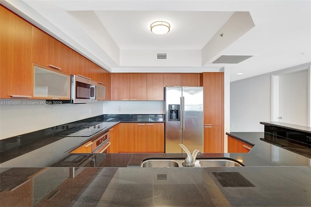 14951 Royal Oaks Ln Unit 1406, North Miami, FL 33181 - kitchen featuring appliances with stainless steel finishes, a sink, a raised ceiling, and brown cabinets