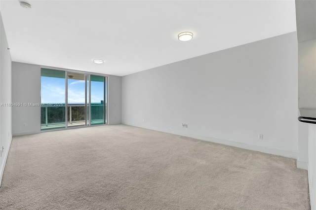 14951 Royal Oaks Ln Unit 1406, North Miami, FL 33181 - unfurnished room with carpet, a wall of windows, baseboards, and a smoke detector