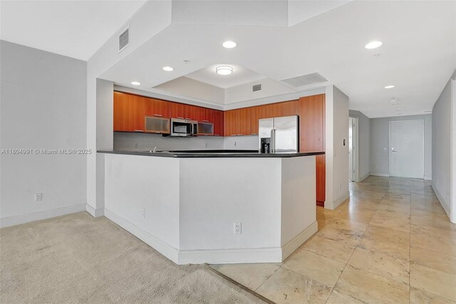 14951 Royal Oaks Ln Unit 1406, North Miami, FL 33181 - kitchen featuring appliances with stainless steel finishes, dark countertops, a peninsula, recessed lighting, and a tray ceiling
