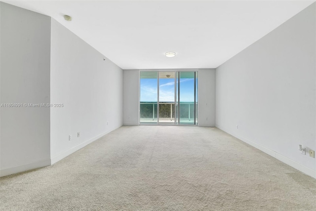 14951 Royal Oaks Ln Unit 1406, North Miami, FL 33181 - spare room featuring carpet floors, expansive windows, baseboards, and a smoke detector