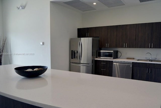 14951 Royal Oaks Ln Unit 1406, North Miami, FL 33181 - kitchen with appliances with stainless steel finishes, a sink, light countertops, dark brown cabinets, and recessed lighting