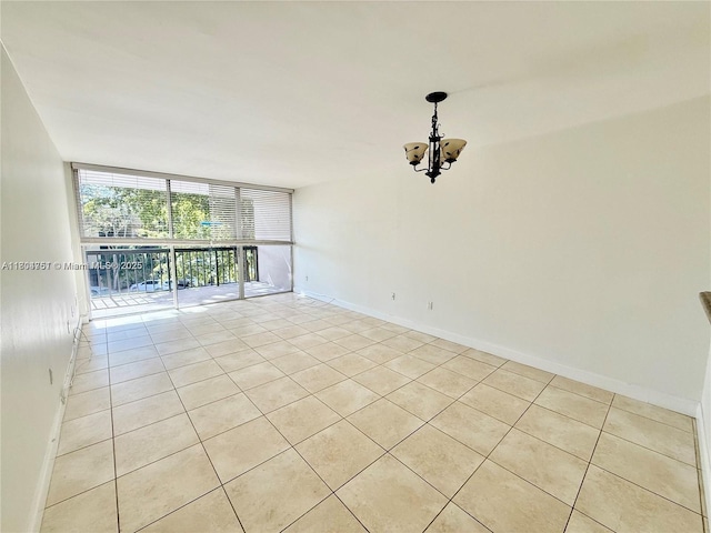 10825 SW 112th Ave Unit 302, Miami, FL 33176 - spare room with light tile patterned floors, a chandelier, a wall of windows, and baseboards