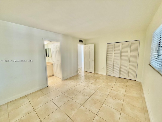10825 SW 112th Ave Unit 302, Miami, FL 33176 - unfurnished bedroom with light tile patterned flooring, a closet, and baseboards