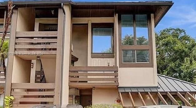 101 SW 96th Ter Unit 204, Plantation, FL 33324 - back of property featuring a standing seam roof, stucco siding, metal roof, and a balcony