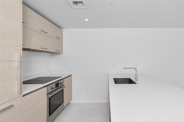 1300 S Miami Ave Unit 3211, Miami, FL 33130 - kitchen featuring oven, black electric stovetop, a sink, light countertops, and light marble finish floors