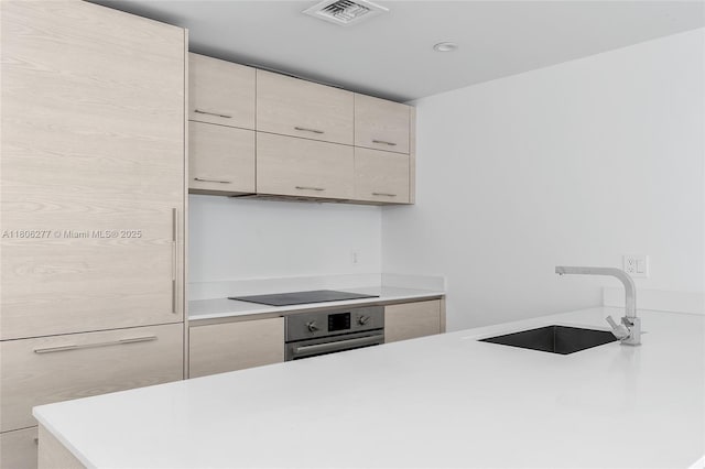 1300 S Miami Ave Unit 3211, Miami, FL 33130 - kitchen with a sink, oven, black electric cooktop, and light countertops