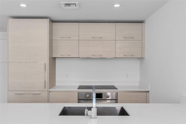 1300 S Miami Ave Unit 3211, Miami, FL 33130 - kitchen featuring modern cabinets, wall oven, light countertops, light brown cabinetry, and recessed lighting