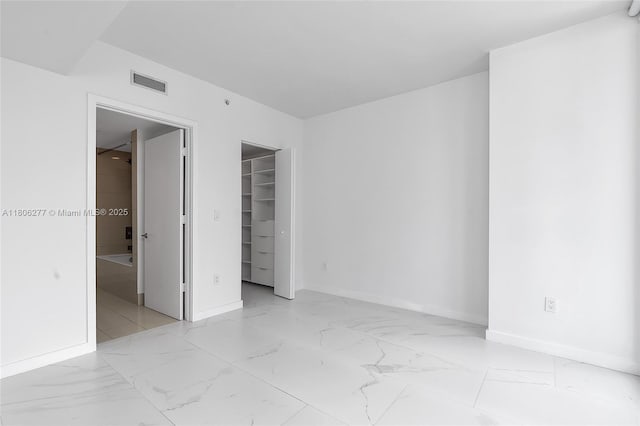 1300 S Miami Ave Unit 3211, Miami, FL 33130 - unfurnished bedroom featuring baseboards, marble look tiles, a walk in closet, and a closet