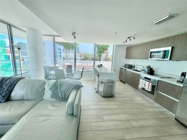 1600 SW 1st Ave Unit 910, Miami, FL 33129 - kitchen with stainless steel appliances, modern cabinets, open floor plan, light countertops, and plenty of natural light