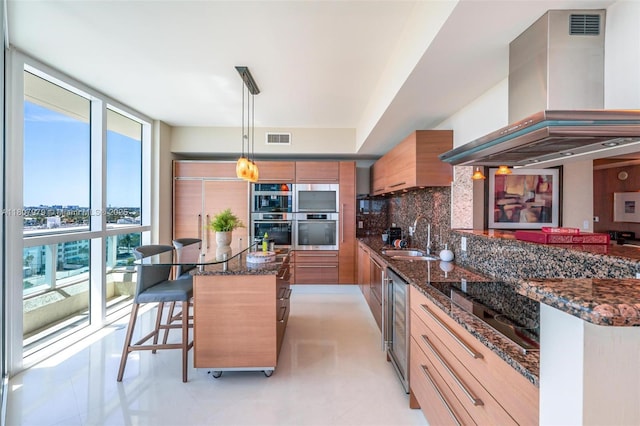 101 S Fort Lauderdale Beach Blvd Unit 1001, Fort Lauderdale, FL 33316 - kitchen featuring a sink, extractor fan, brown cabinetry, beverage cooler, and a breakfast bar
