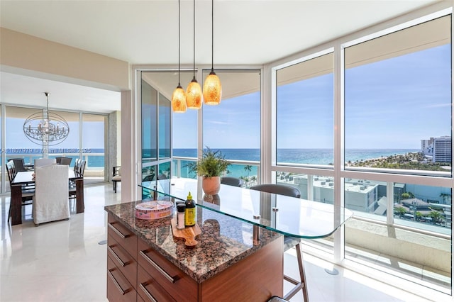 101 S Fort Lauderdale Beach Blvd Unit 1001, Fort Lauderdale, FL 33316 - kitchen with expansive windows, a water view, a chandelier, dark stone countertops, and pendant lighting