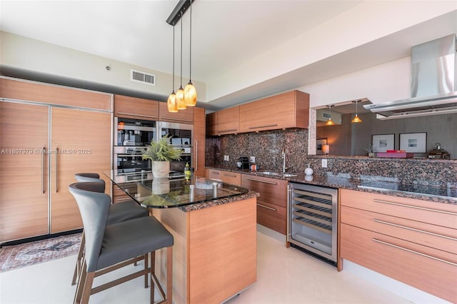 101 S Fort Lauderdale Beach Blvd Unit 1001, Fort Lauderdale, FL 33316 - kitchen featuring wine cooler, backsplash, paneled fridge, range hood, and brown cabinetry