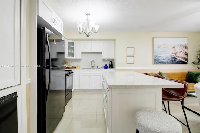 7891 SW 9th Ter, Miami, FL 33144 - kitchen with black appliances, a sink, a kitchen island, light countertops, and a chandelier