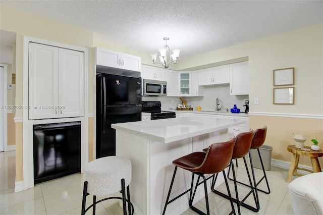 7891 SW 9th Ter, Miami, FL 33144 - kitchen featuring black appliances, a sink, white cabinets, a kitchen bar, and a chandelier
