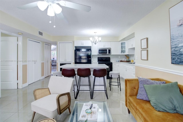 7891 SW 9th Ter, Miami, FL 33144 - kitchen featuring black appliances, a center island, glass insert cabinets, light countertops, and a chandelier
