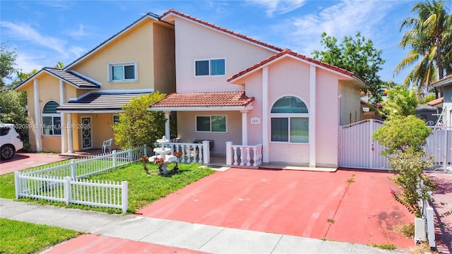 7891 SW 9th Ter, Miami, FL 33144 - view of front of house with a tile roof, covered porch, stucco siding, and a gate