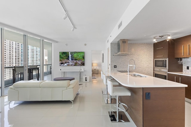 495 Brickell Ave Unit 2304, Miami, FL 33131 - kitchen with a sink, light countertops, backsplash, oven, and a kitchen bar