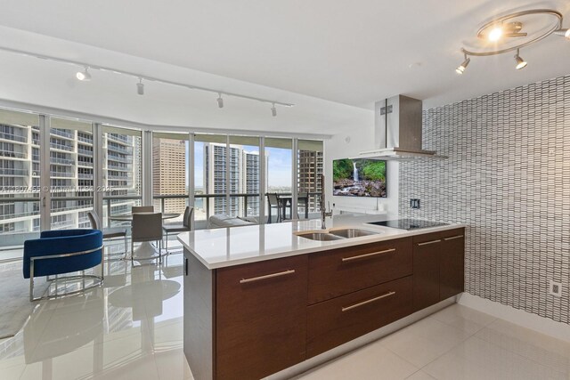 495 Brickell Ave Unit 2304, Miami, FL 33131 - kitchen with track lighting, modern cabinets, wall chimney exhaust hood, light countertops, and light tile patterned floors