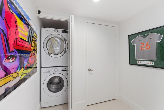 495 Brickell Ave Unit 2304, Miami, FL 33131 - washroom featuring stacked washing machine and dryer, tile patterned flooring, and baseboards