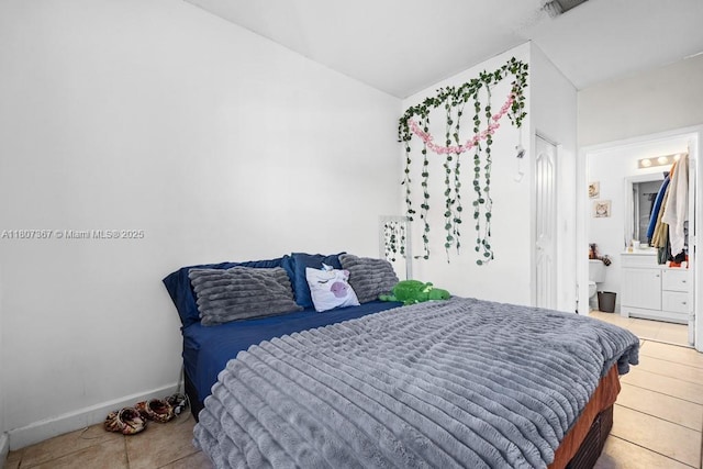 15490 SW 18th Ln, Miami, FL 33185 - bedroom with light tile patterned floors, baseboards, and ensuite bath