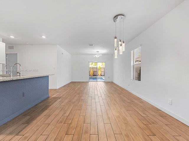 501 NE 6th Ct, Florida City, FL 33034 - unfurnished living room featuring a sink, light wood-style floors, baseboards, and recessed lighting