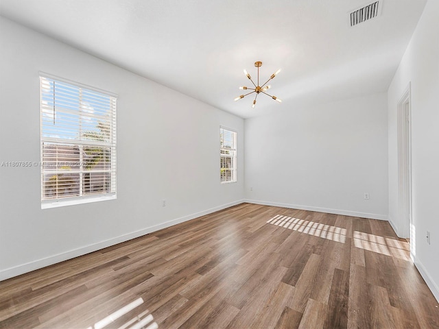 501 NE 6th Ct, Florida City, FL 33034 - empty room featuring a chandelier, wood finished floors, and baseboards