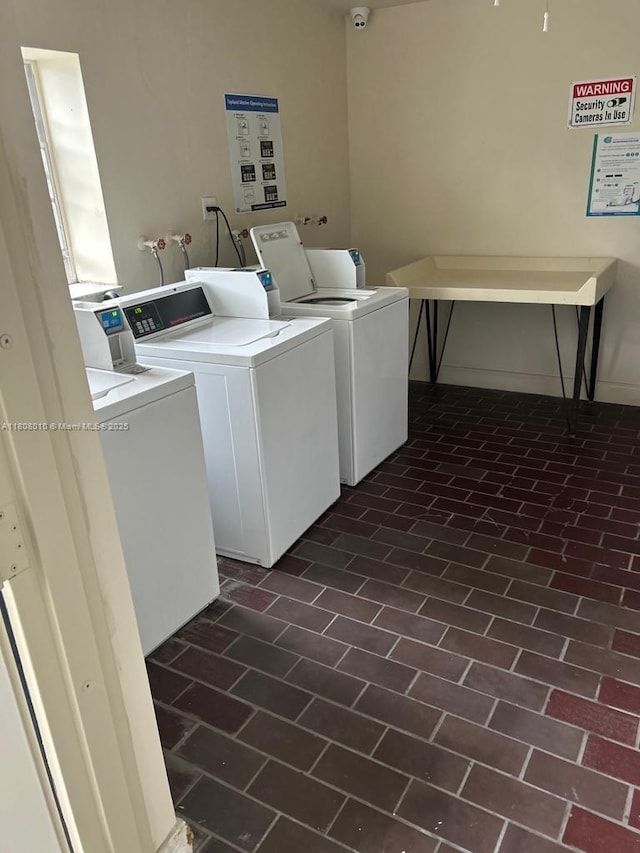 16750 NE 10th Ave Unit 225, North Miami Beach, FL 33162 - shared laundry room featuring washing machine and clothes dryer and brick patterned flooring