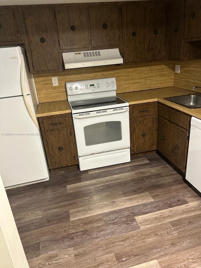 16750 NE 10th Ave Unit 225, North Miami Beach, FL 33162 - kitchen with white appliances, custom range hood, dark brown cabinets, and dark wood-type flooring
