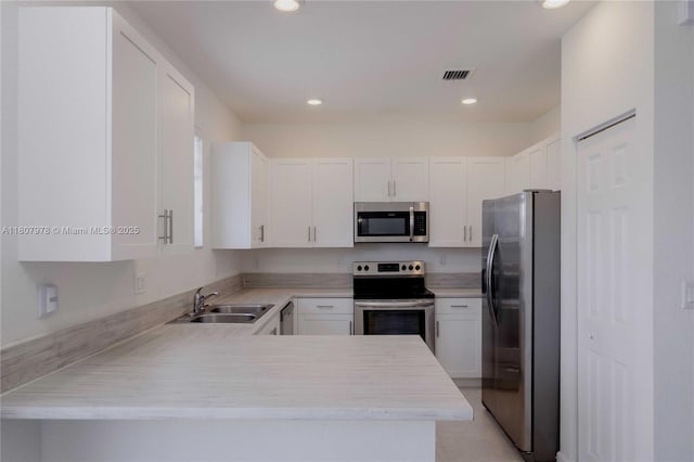 10260 SW 228th Ter Unit 10260, Miami, FL 33190 - kitchen featuring appliances with stainless steel finishes, a sink, light countertops, white cabinets, and a peninsula