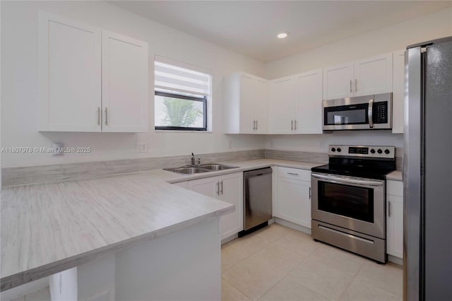 10260 SW 228th Ter Unit 10260, Miami, FL 33190 - kitchen featuring appliances with stainless steel finishes, a sink, white cabinetry, a peninsula, and light countertops
