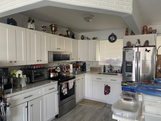 2427 Garland Cir Unit 195, Hollywood, FL 33021 - kitchen featuring stainless steel appliances, a sink, tasteful backsplash, white cabinetry, and light countertops
