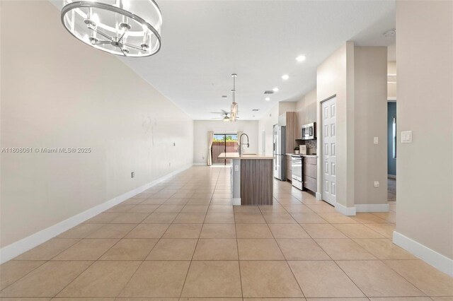 7825 NW 104th Ave Unit 4, Doral, FL 33178 - kitchen featuring appliances with stainless steel finishes, an island with sink, a chandelier, open floor plan, and light countertops