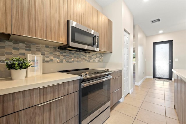 7825 NW 104th Ave Unit 4, Doral, FL 33178 - kitchen with appliances with stainless steel finishes, decorative backsplash, light countertops, light tile patterned floors, and baseboards