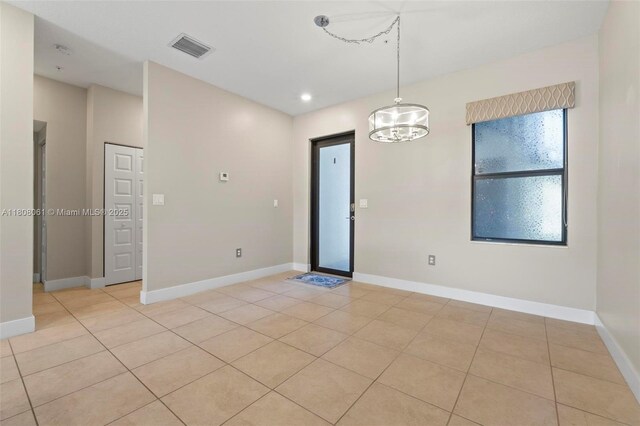 7825 NW 104th Ave Unit 4, Doral, FL 33178 - spare room featuring light tile patterned floors, a chandelier, and baseboards