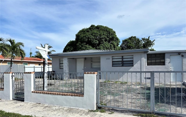 650 E 55th St, Hialeah, FL 33013 - view of front of house with a fenced front yard, a porch, a gate, and stucco siding