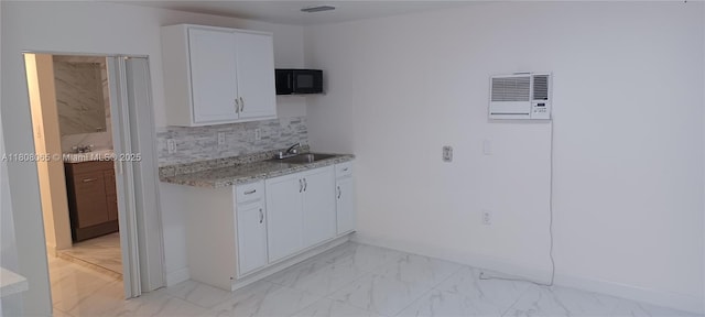 650 E 55th St, Hialeah, FL 33013 - kitchen with black microwave, light marble finish flooring, white cabinetry, and decorative backsplash