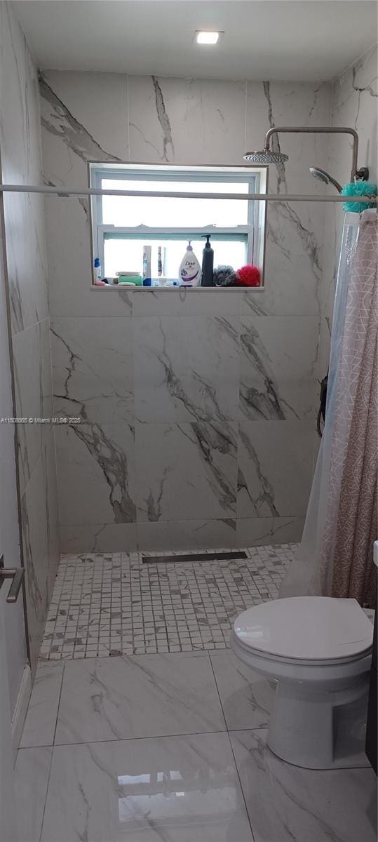 650 E 55th St, Hialeah, FL 33013 - full bath with a marble finish shower and marble look tiles
