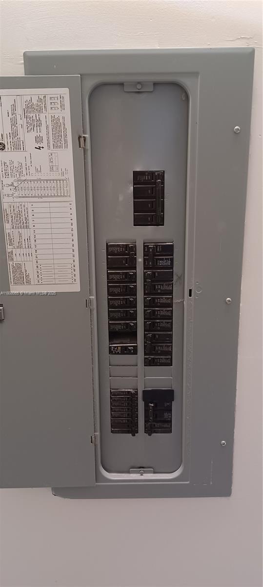 650 E 55th St, Hialeah, FL 33013 - utility room featuring electric panel