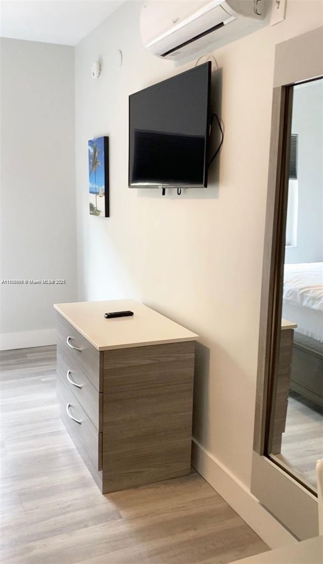 763 Pennsylvania Ave Unit 101, Miami Beach, FL 33139 - detailed view of wood finished floors, baseboards, and a wall mounted AC