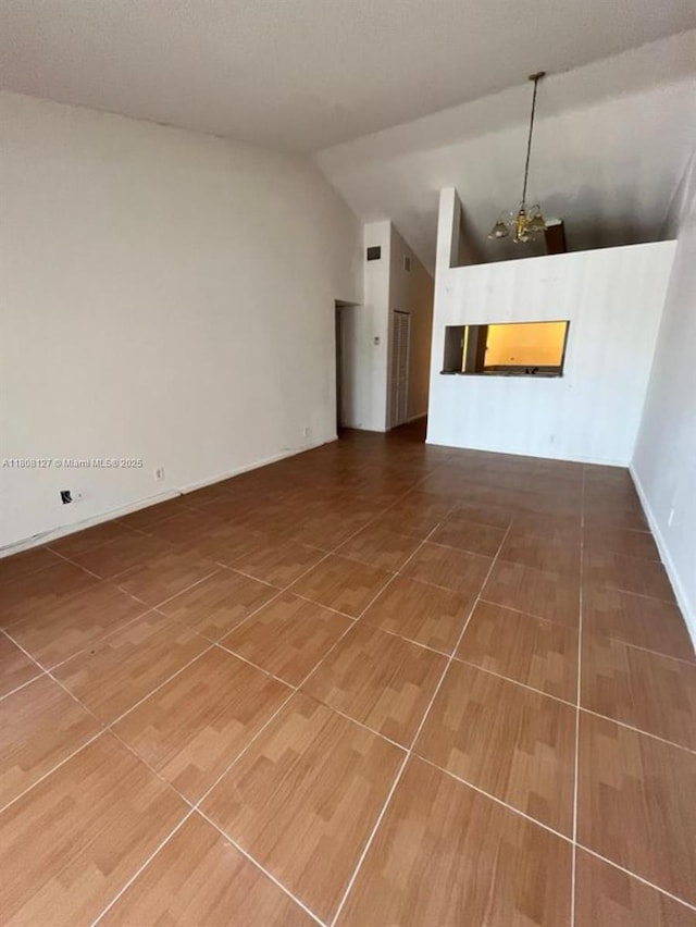 2421 NW 56th Ave Unit 2-202, Lauderhill, FL 33313 - unfurnished living room with lofted ceiling and a chandelier
