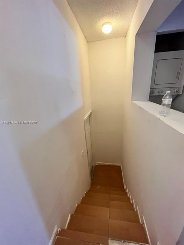2421 NW 56th Ave Unit 2-202, Lauderhill, FL 33313 - stairway featuring stacked washing machine and dryer and a textured ceiling