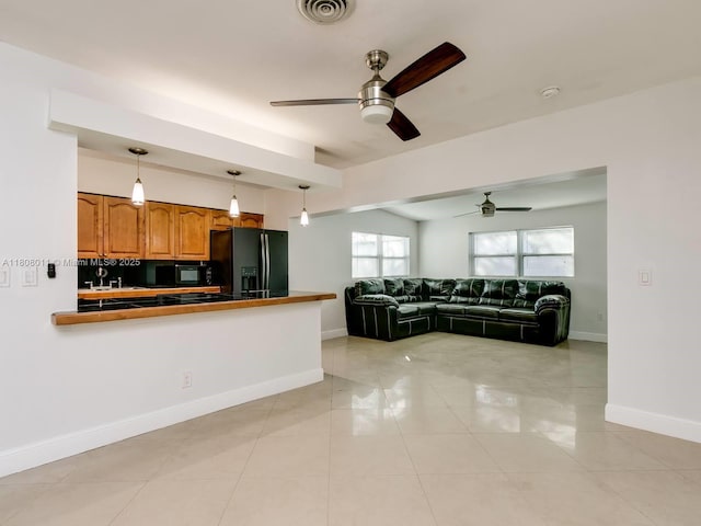 870 NE 182nd St, North Miami Beach, FL 33162 - kitchen with black appliances, a ceiling fan, brown cabinets, pendant lighting, and baseboards