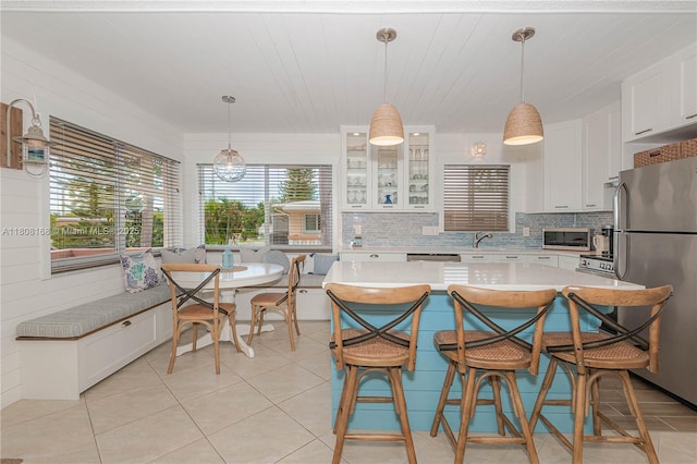 1050 SW 11th St Unit 20L, Hallandale Beach, FL 33009 - kitchen with stainless steel appliances, a sink, light countertops, white cabinets, and a kitchen bar